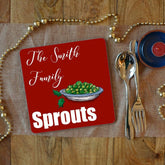 a personalised sprouts Christmas placemat with white text which says "the Smith family sprouts" on a red background